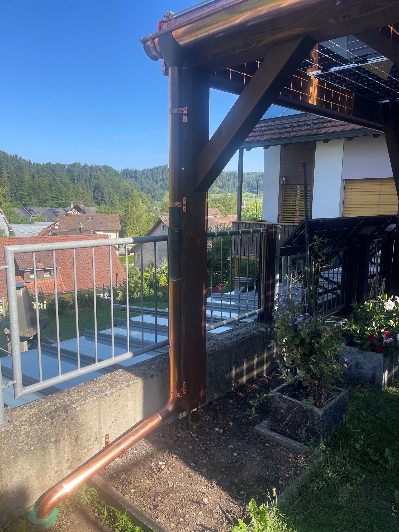 Kupfer-Regenrohr an einer Holz-Pergola