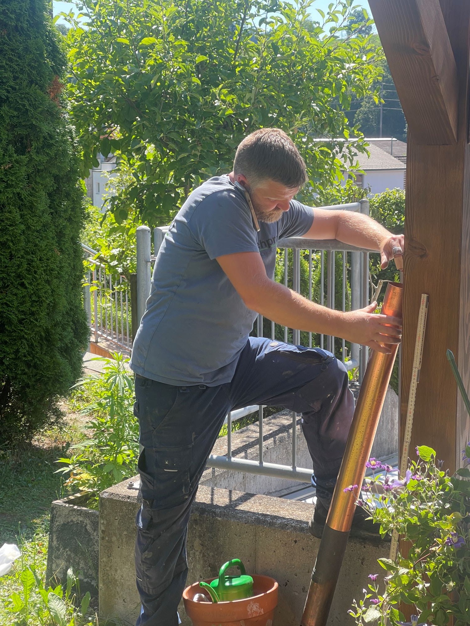 Mitarbeiter montiert ein Kupfer-Fallrohr